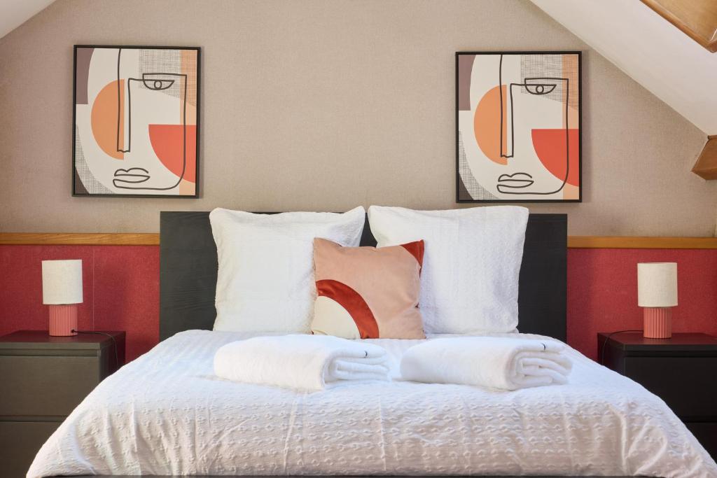 une chambre avec un lit avec deux tableaux au mur dans l'établissement Grande maison familiale à 30 min de Paris, à Brunoy