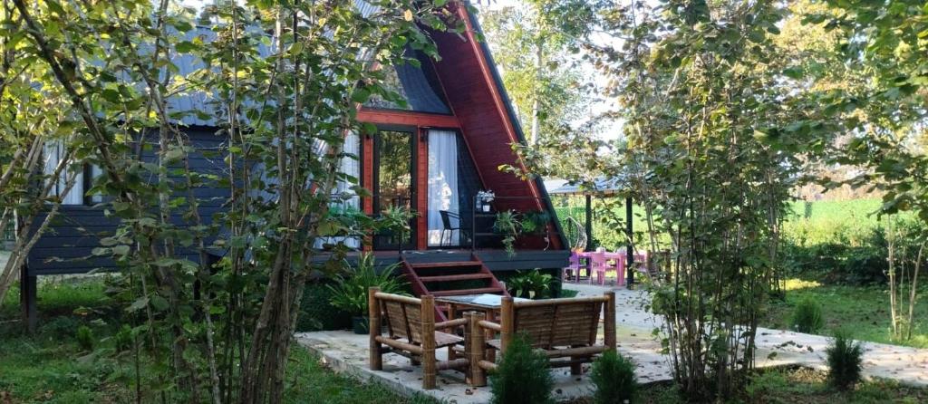 two benches sitting in front of a house at Romantic Villa 2BR by the Sea in Tsikhisdziri