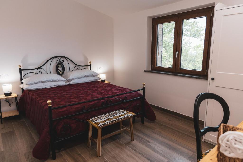 un dormitorio con una cama y una ventana en Casetta Mentuccia, en San Ginesio