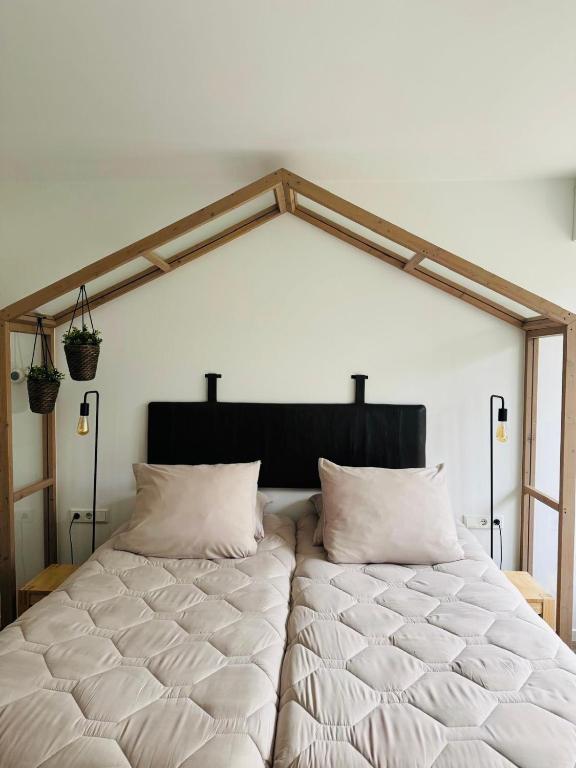 a large white bed with two pillows in a room at B&B Bij tante Teun in Naaldwijk