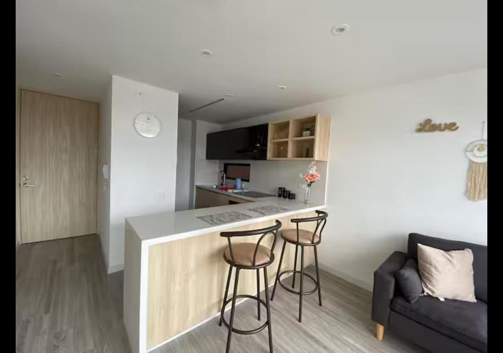 eine Küche mit Theke und zwei Barhockern in der Unterkunft Penthouse Infinity Rooftop Pool, Walk to Zona T in Bogotá