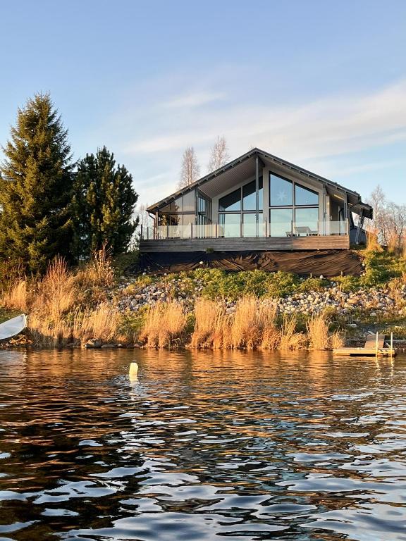 a house on the edge of a body of water at Aurora Arctic Riverside Villa in Rovaniemi