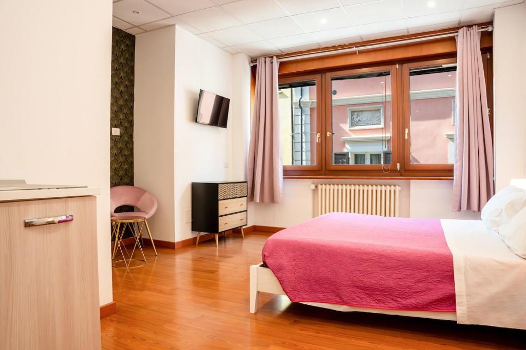 a hotel room with a bed and a window at LHE Les Trois Merveilles Rosé Charles in Cesena