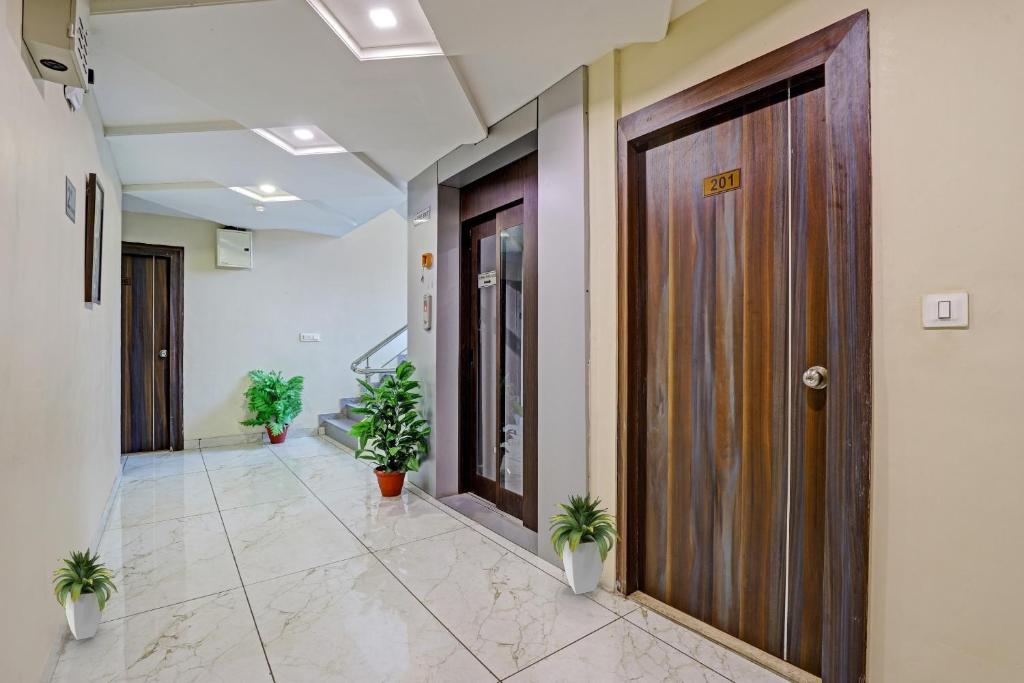 an office hallway with doors and potted plants at Collection O Hotel Raj Palace in Vadodara