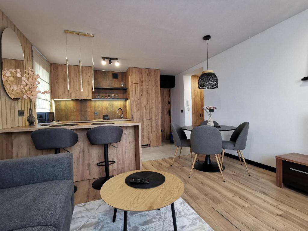 een woonkamer en een keuken met een tafel en stoelen bij Apartament Opawska 2 in Gliwice