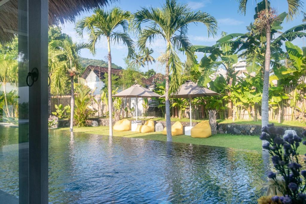 a view of a swimming pool with palm trees at OMAÏA Private villas in Amed