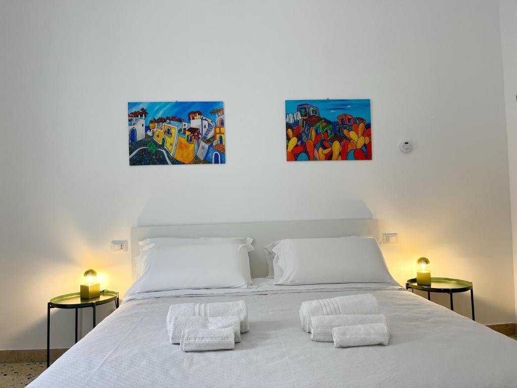 ein Schlafzimmer mit einem weißen Bett mit Handtüchern darauf in der Unterkunft Palermo central stay in Palermo