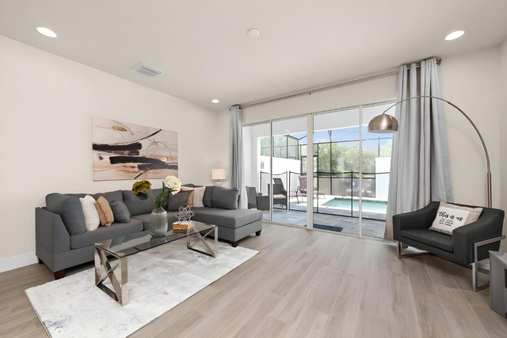 a living room with a couch and a table at Cozy 3bd 3bath @HiddenForest with pool in Orlando