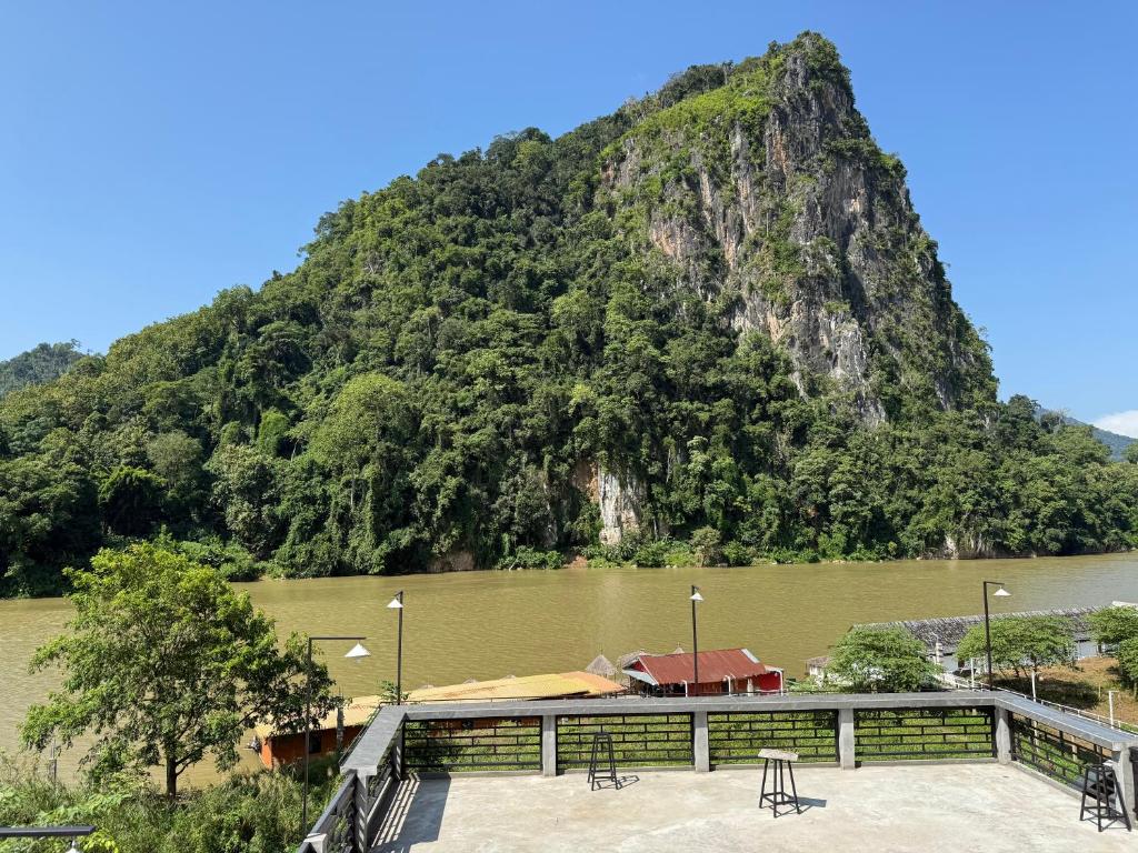 a mountain next to a body of water with a building at Amanda Boutique in Nongkhiaw