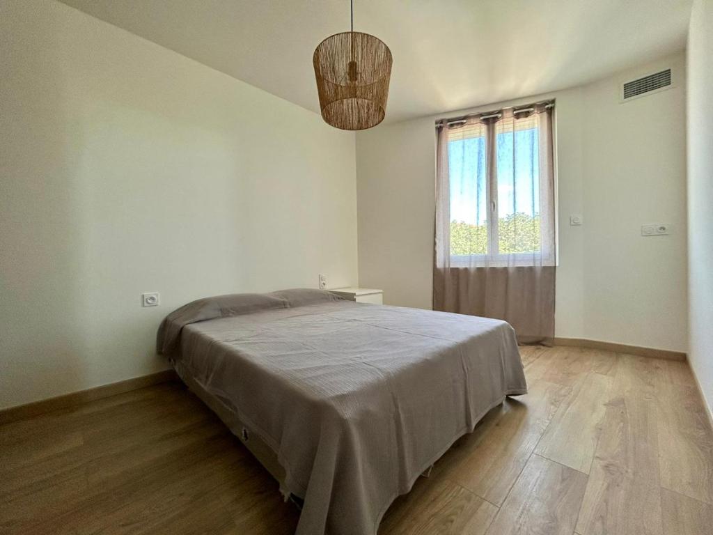 a white bedroom with a bed and a window at Colocation Étudiante bompas in Bompas