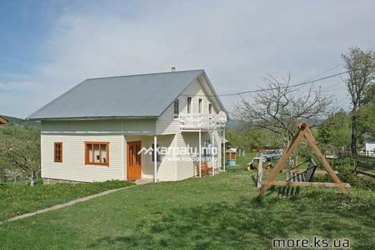 a white house with a gray roof in a yard at Кубаново in Kozmacz