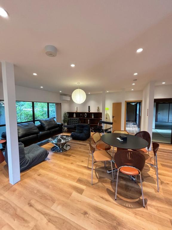 a living room with a couch and a table and chairs at 雲の家 旧東海道沿いの畑宿の温もりステイ in Hakone