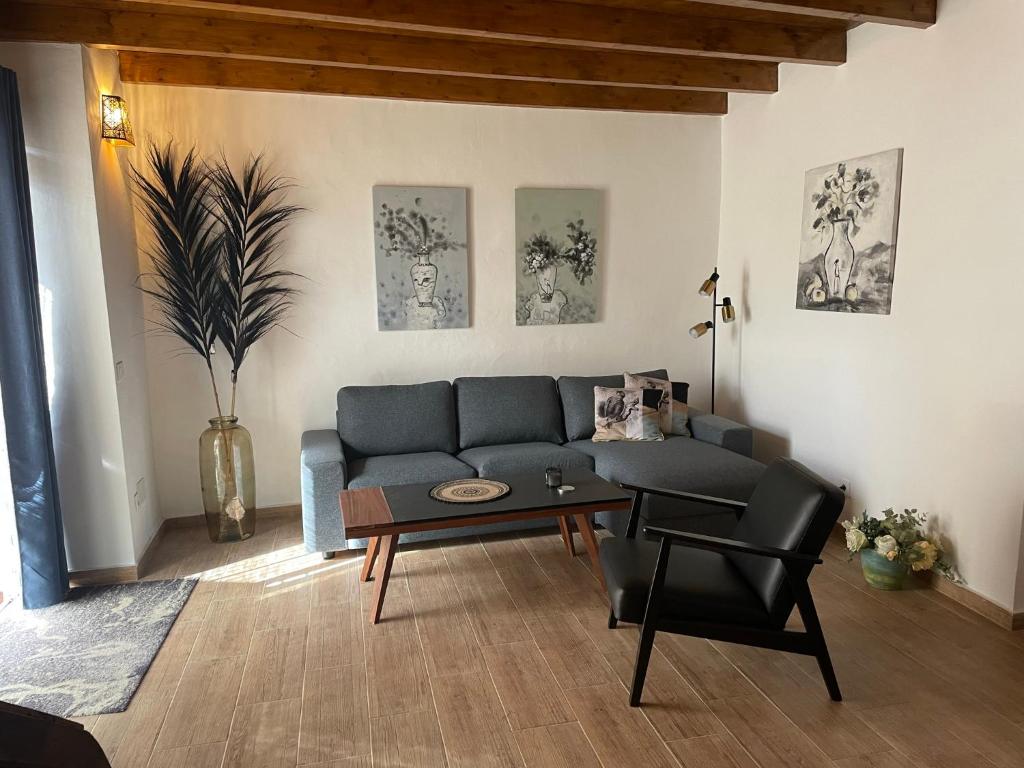 a living room with a blue couch and a table at Casita Ricarda in Tazacorte