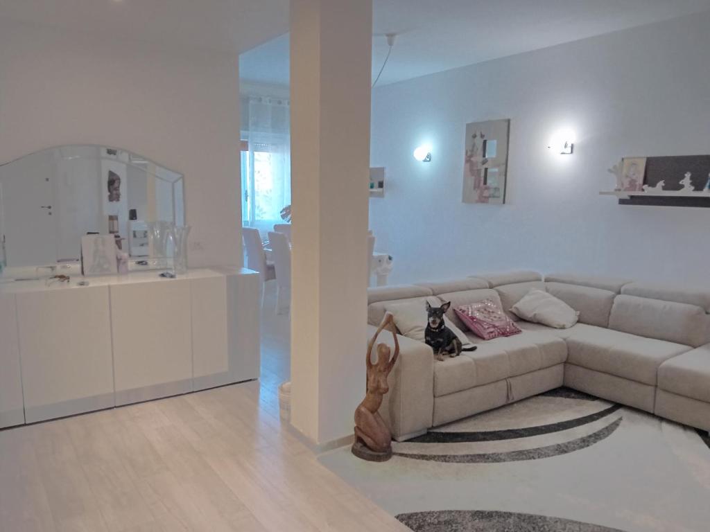 un salon avec un canapé et une cuisine dans l'établissement Appartamento Zaira, à Grosseto