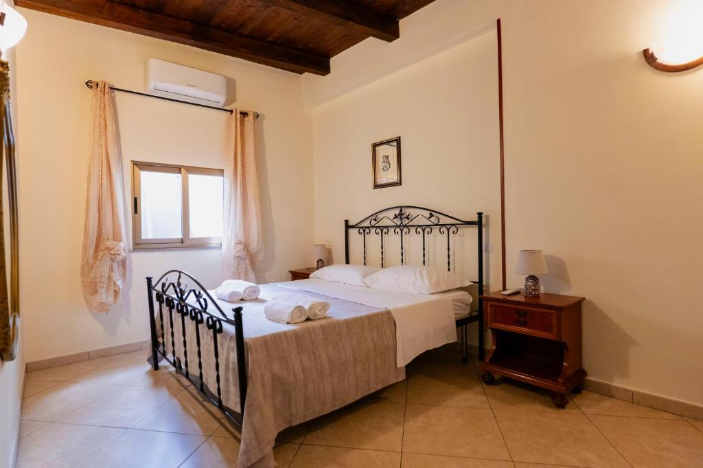 レッジョ・ディ・カラブリアにあるLuna di Sale - Romantic Sea Rooms & Apartmentsのベッドとテーブルと窓のある寝室