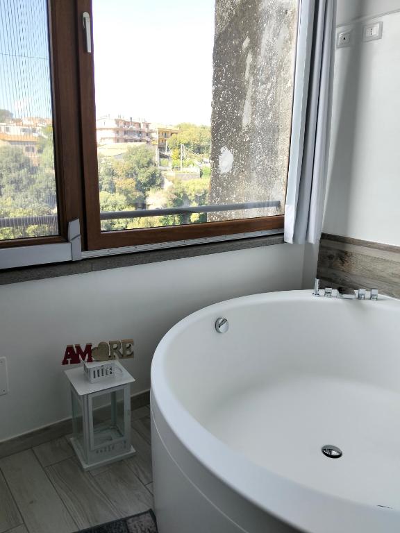 a bathroom with a white tub and a window at La casa nel Borgo Sospeso "con vasca "no idro " e vista panoramica" in Vitorchiano
