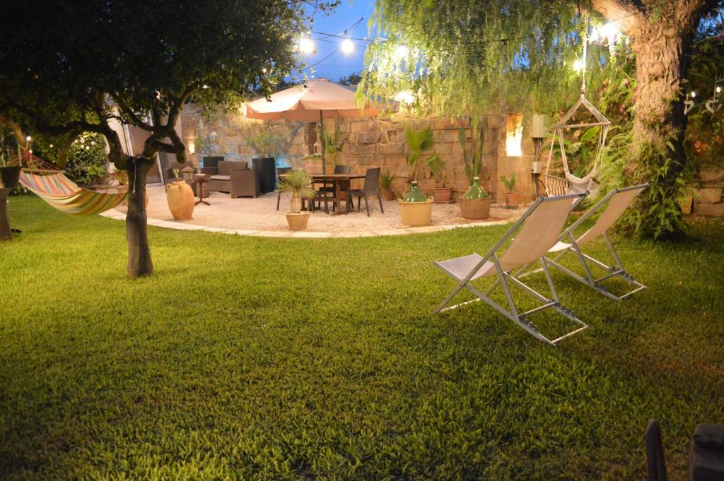 two lawn chairs in a yard with a patio at Villa De Santis Gallipoli Relax e Natura in Gallipoli