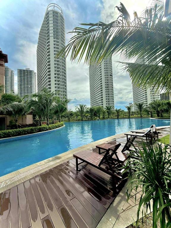 西哈努克SB Condo Sihanoukville -700m to U MALL的一个带两张野餐桌的游泳池和两栋高楼