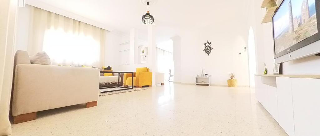 Una sala de estar blanca con un sofá y una mesa. en N17 Bis, en Dar el Ouzir