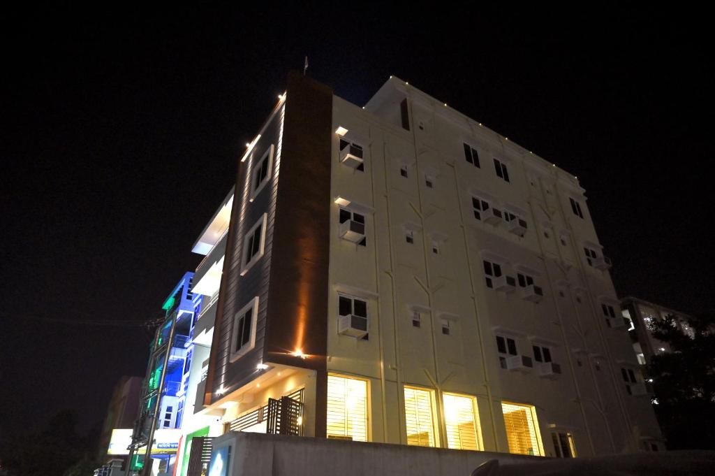een hoog gebouw met 's nachts verlichting bij Stanza Premium Hotels in Bhubaneshwar