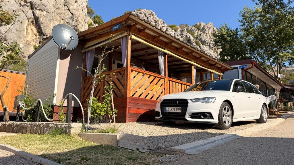 a white car parked in front of a house at Mobile home MARIS in Sveti Juraj