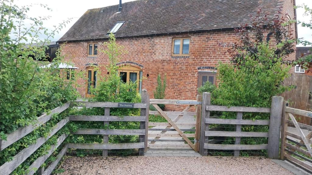 a wooden fence in front of a brick house at The Stables in Droitwich