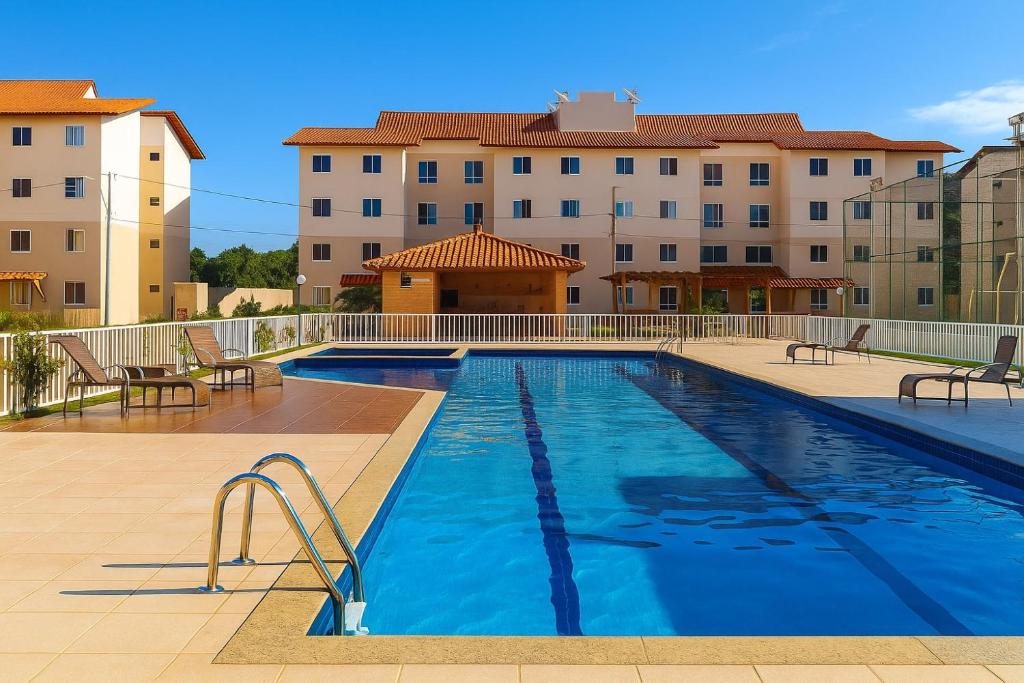 a large swimming pool in front of a building at Apartamento Cantinho na Praia in Ilhéus