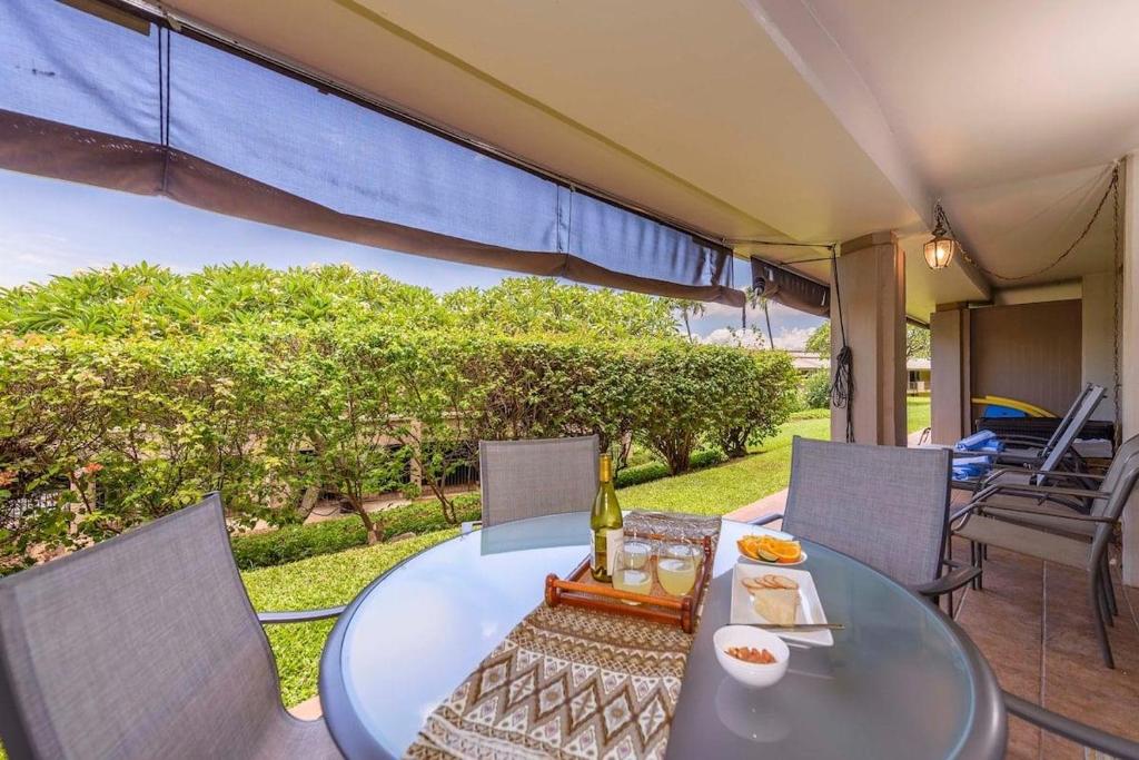 a glass table and chairs on a patio at Eldorado K102 · EL K102 Relax Unwind Recharge 1BD w Pool AC in Kahana