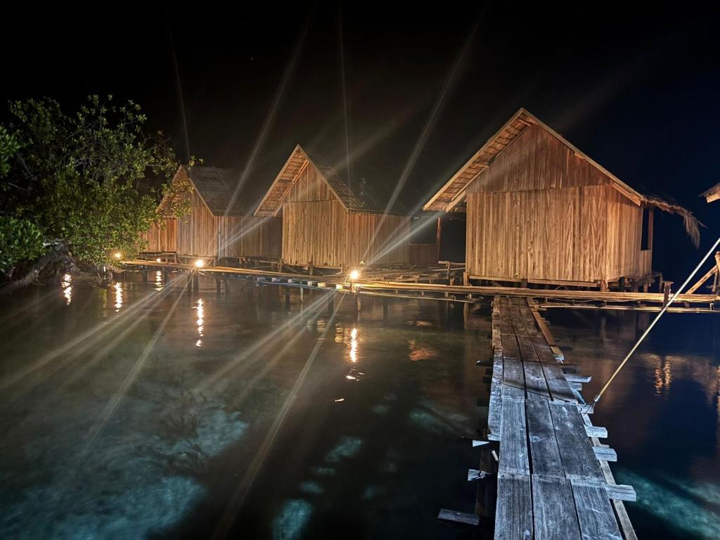 a row of wooden huts on a dock at night at Miguel Homestay in Besir