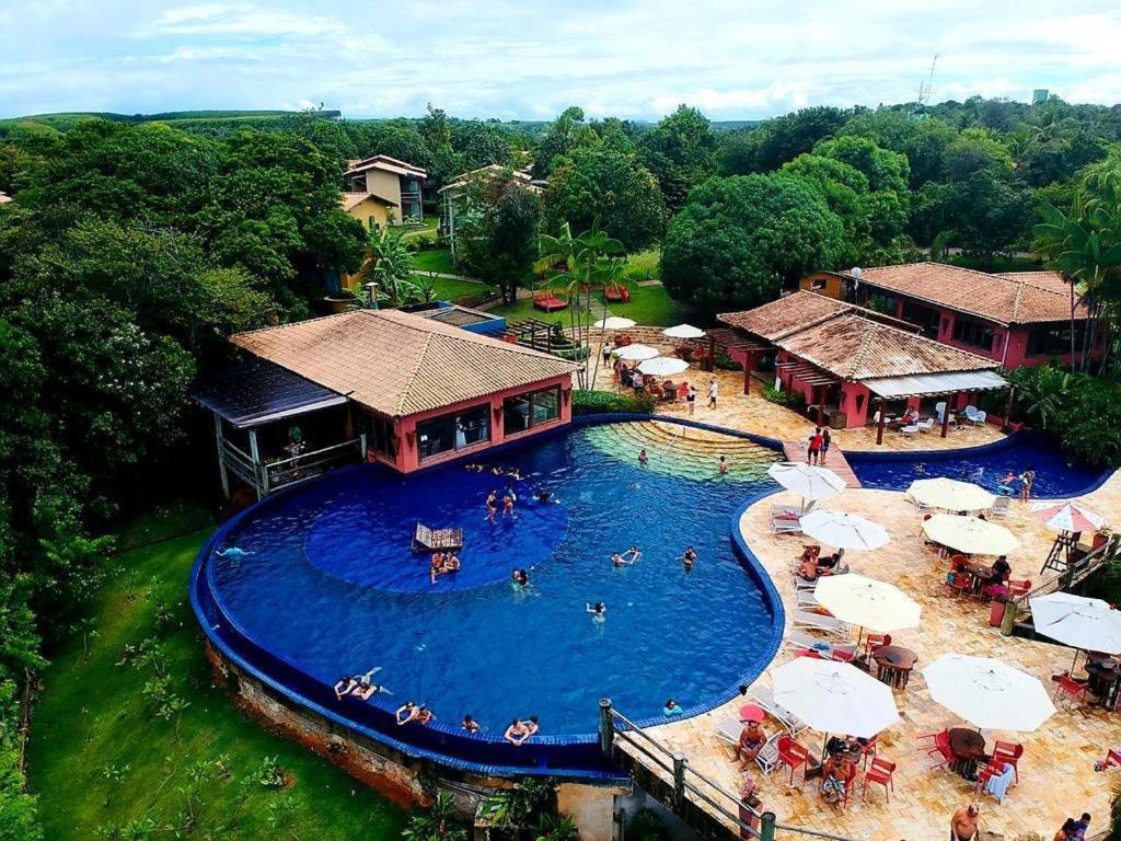 une vue aérienne d'une piscine dans un complexe hôtelier dans l'établissement Chalé das flores, à Maceió