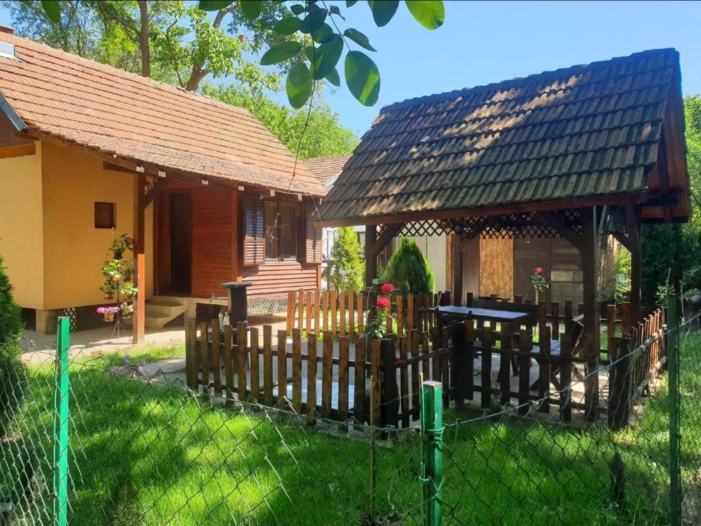 une maison avec une clôture en bois devant dans l'établissement Radetov konak, à Ðunis