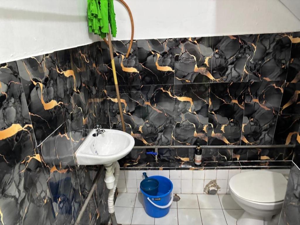 a bathroom with a sink and a toilet at Kuzha Homestay in Kota Kinabalu