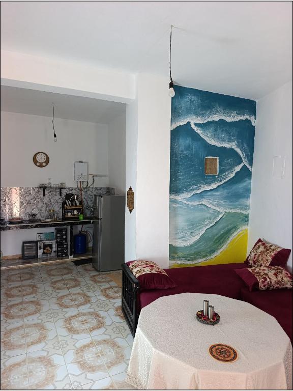 a living room with a couch and a table at earth home in Imzoûrene