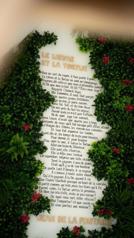 a wall with areath of flowers on it at Le Refuge Des Saisons in Barisis-aux-Bois