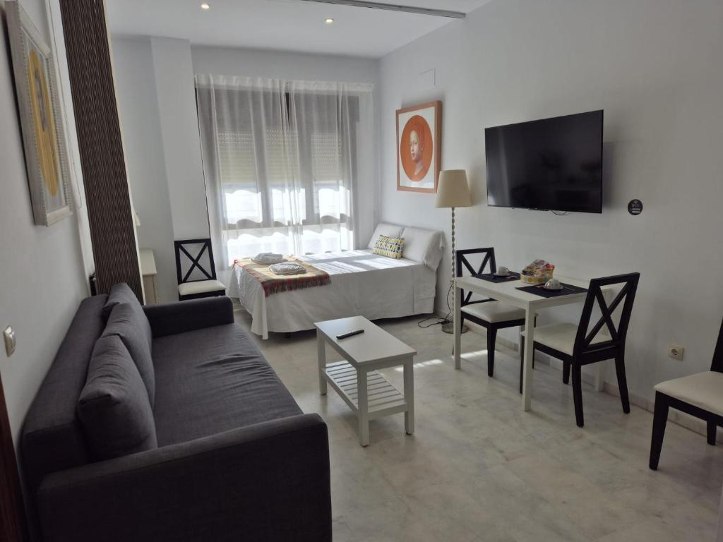 a living room with a couch and a table at Apartamento Deluxe 1 Room Piscina Parking LuxSevilla Bormujos in Bormujos