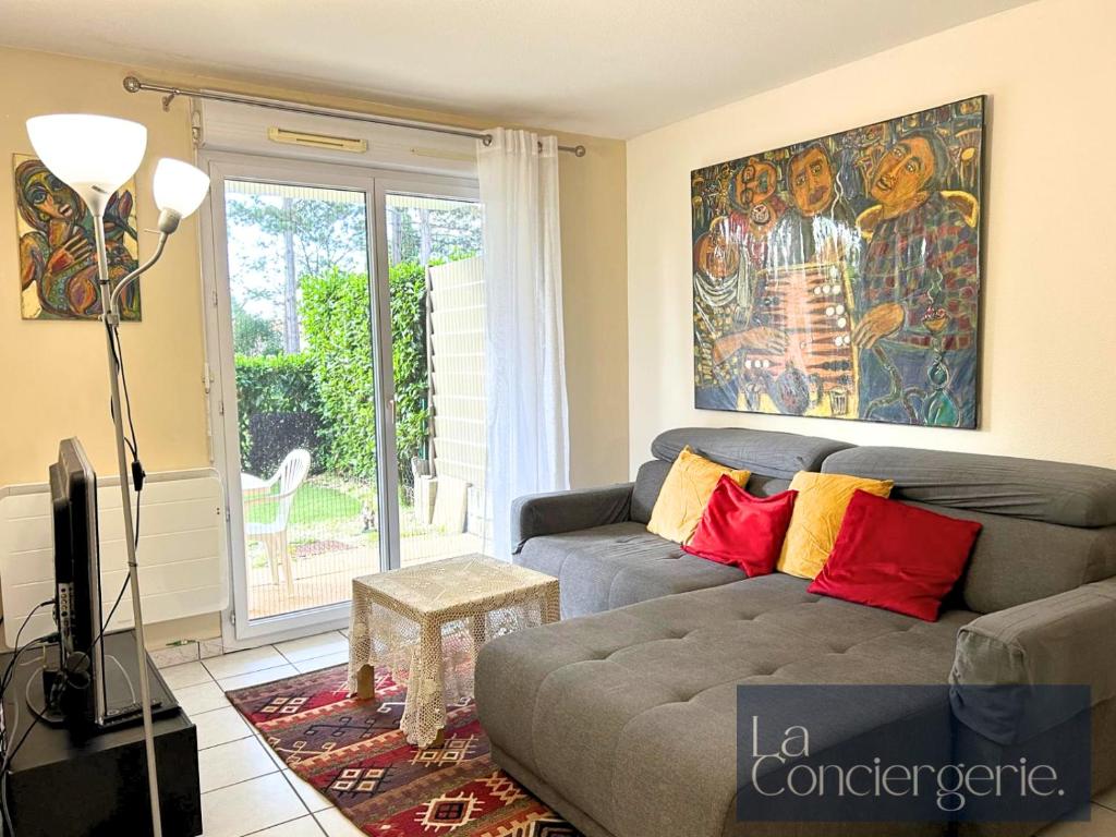 een woonkamer met een bank en een schilderij aan de muur bij L'Atelier 6 - Poitiers in Mignaloux-Beauvoir