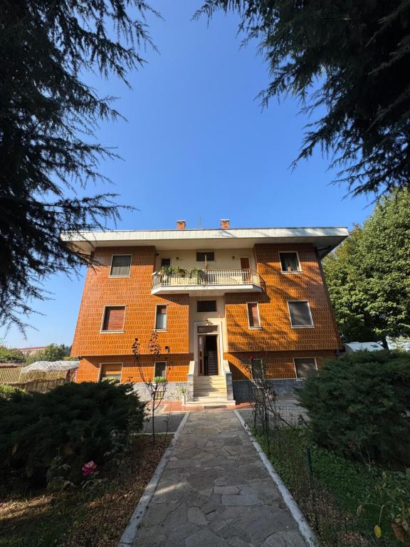 ein großes Backsteingebäude mit einem Gehweg davor in der Unterkunft La casa i due cedri in Cuneo