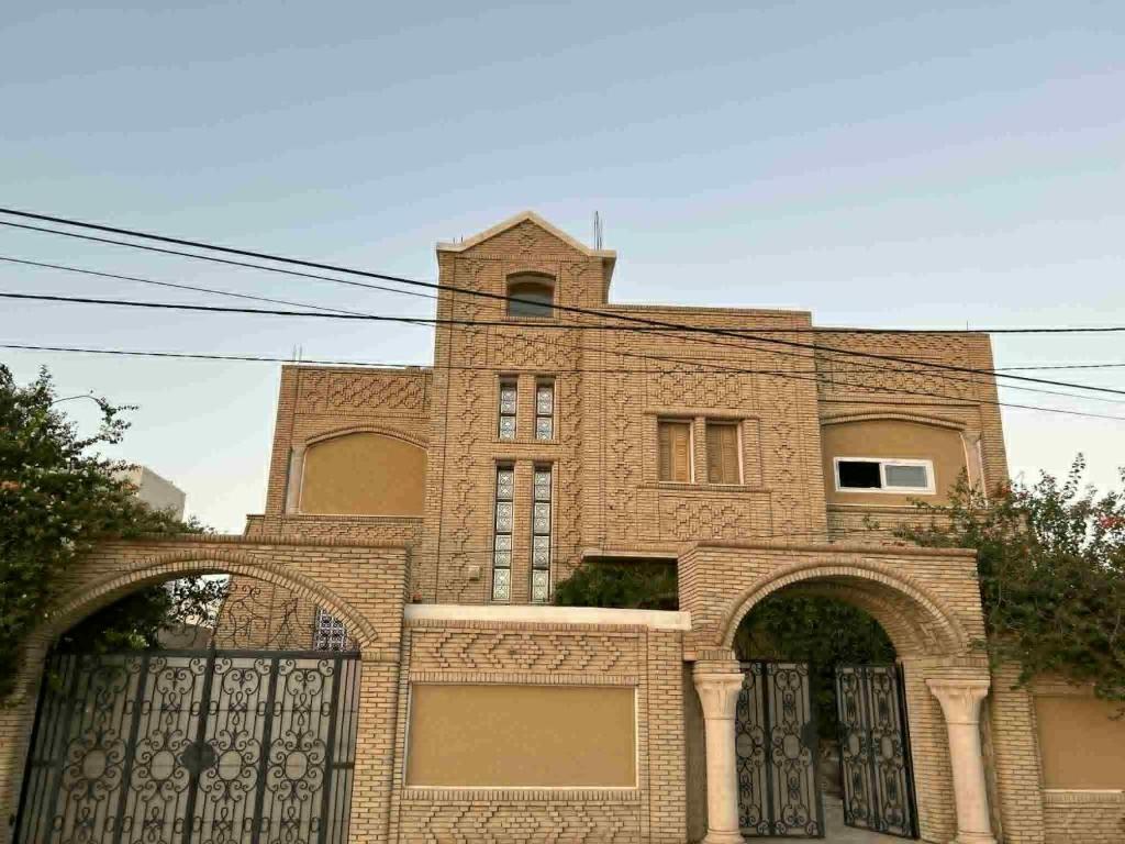 a large brick building with a gate in front of it at Dar Naifer in Tozeur