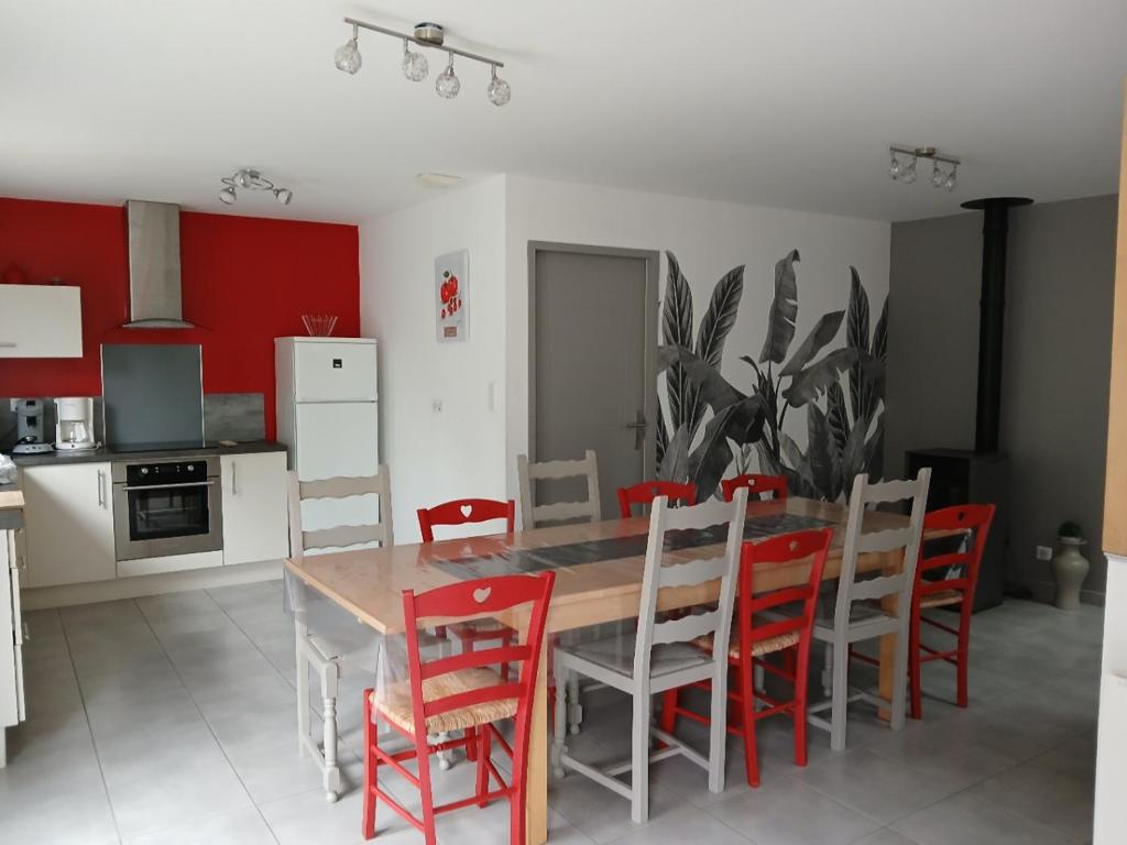 a kitchen with a wooden table and red chairs at Gîte La Rocardière XL 10 personnes in Mouchamps