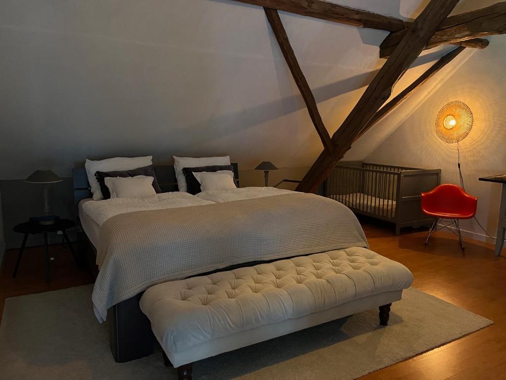 a bedroom with a white bed with a white tufted bedskirts at Vakantiewoning Fruitschuur de Morel in Venlo