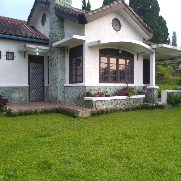 a white house with a lawn in front of it at Villa Montana 2 in Cicadas