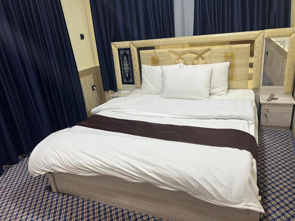 カブールにあるStar Shirpoor Guest Houseの木製のヘッドボードが付いた大きなベッドのある寝室