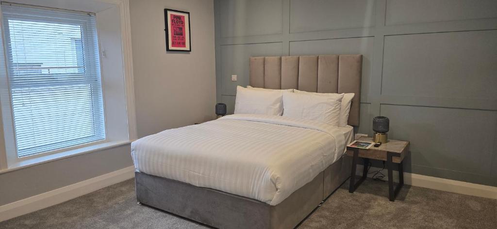 a bedroom with a large bed with white sheets and a window at Martins Lane Guesthouse in Mullingar