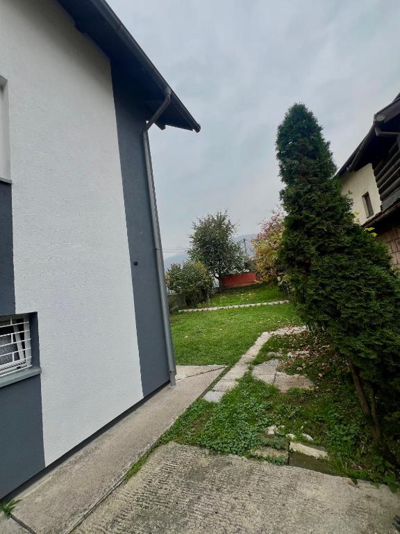 SvrakeにあるVila Nedimの白い建物と庭の隣にある木