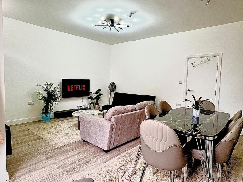 ein Wohnzimmer mit einer Couch und einem Glastisch in der Unterkunft Luxury Apartment with Grand Living Space London in London