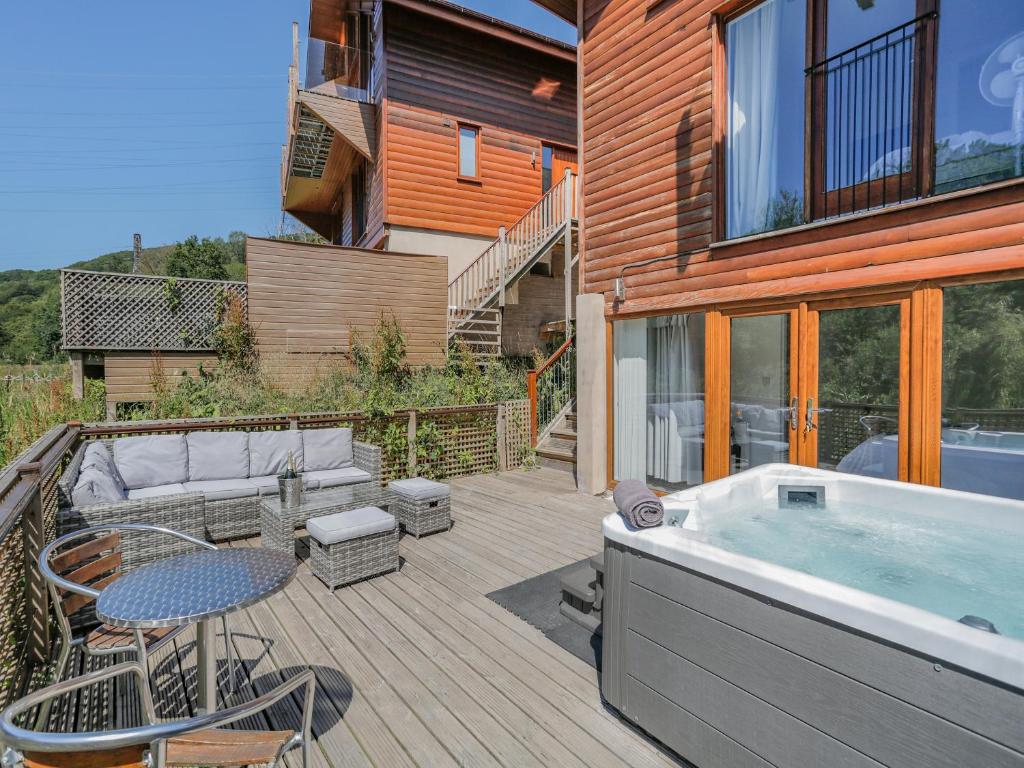 a deck with a hot tub and a table and chairs at Waterside Lodge Fourteen - Uk36707 in Elland