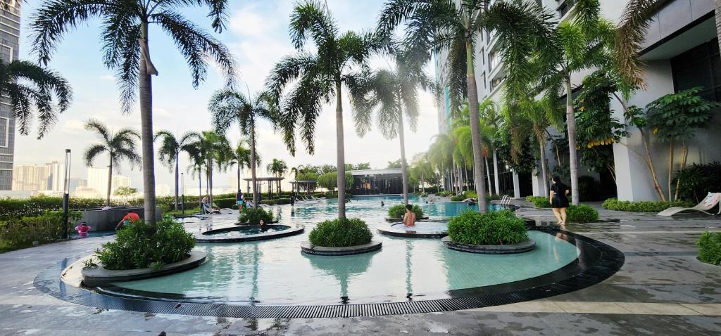 a pool with palm trees in a building at Trion Signature Luxe Suites KL in Kuala Lumpur