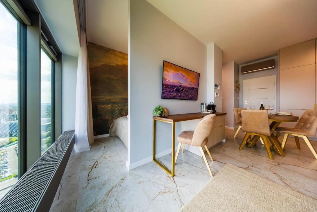 a room with a table and chairs and a dining room at OLSZYNKI PARK 2- High-End Luxury Apartment with View, City Centre by StayNest in Rzeszów