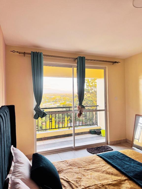 a bedroom with a bed and a large window at Sunshine Home in Nanyuki