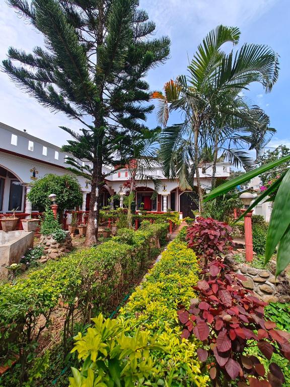 a house with a garden with flowers and trees at Red Stone villa in Masinagudi